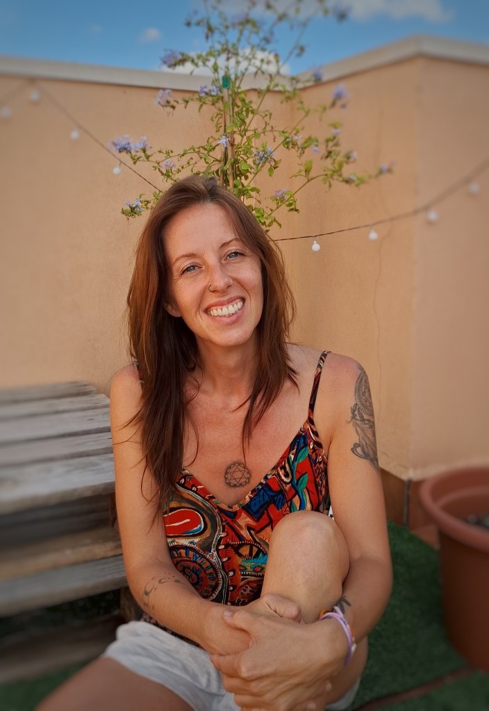 Marta Pimentel. Creadora de crea tu yoga. Gesto natural y sonriente, rodeada de elementos naturales. 